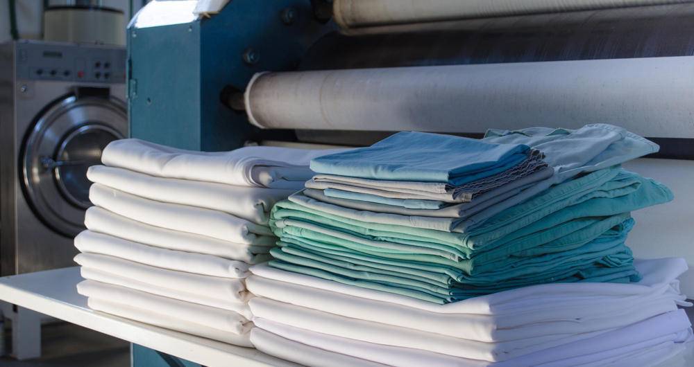 Stack,Of,Folded,Clean,Sheets,Or,Fabrics,And,Industrial,Iron