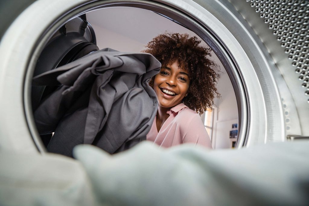 Beautiful woman in Pacific Beach, California is doing laundry and holding a basket of clean clothes. 